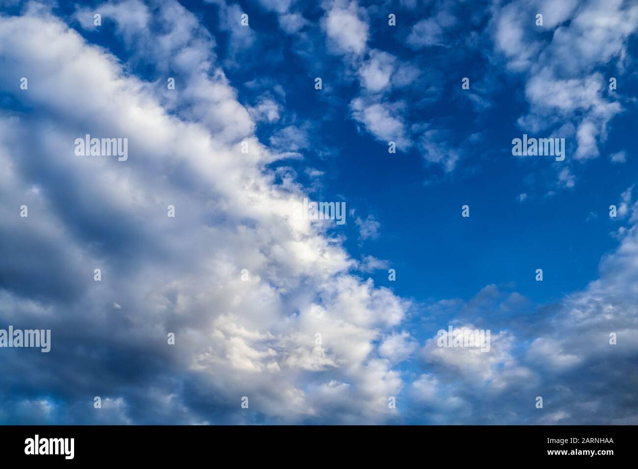 Beautiful white fluffy cumulus and cirrus clouds in a deep blue sky ...