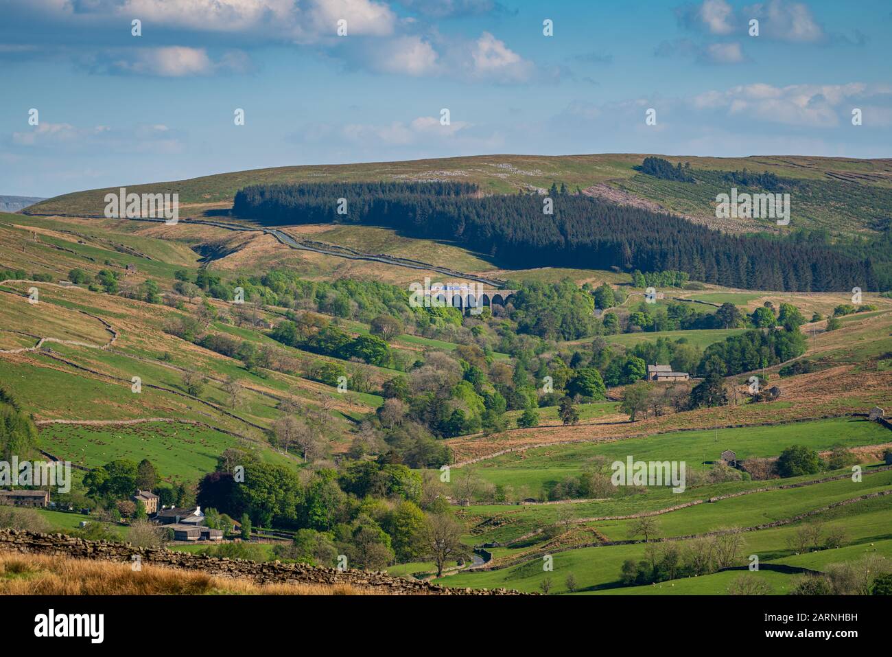 Near Cowgill, Cumbria, England, UK May 16, 2019 A train passing the Dent Head Viaduct on the