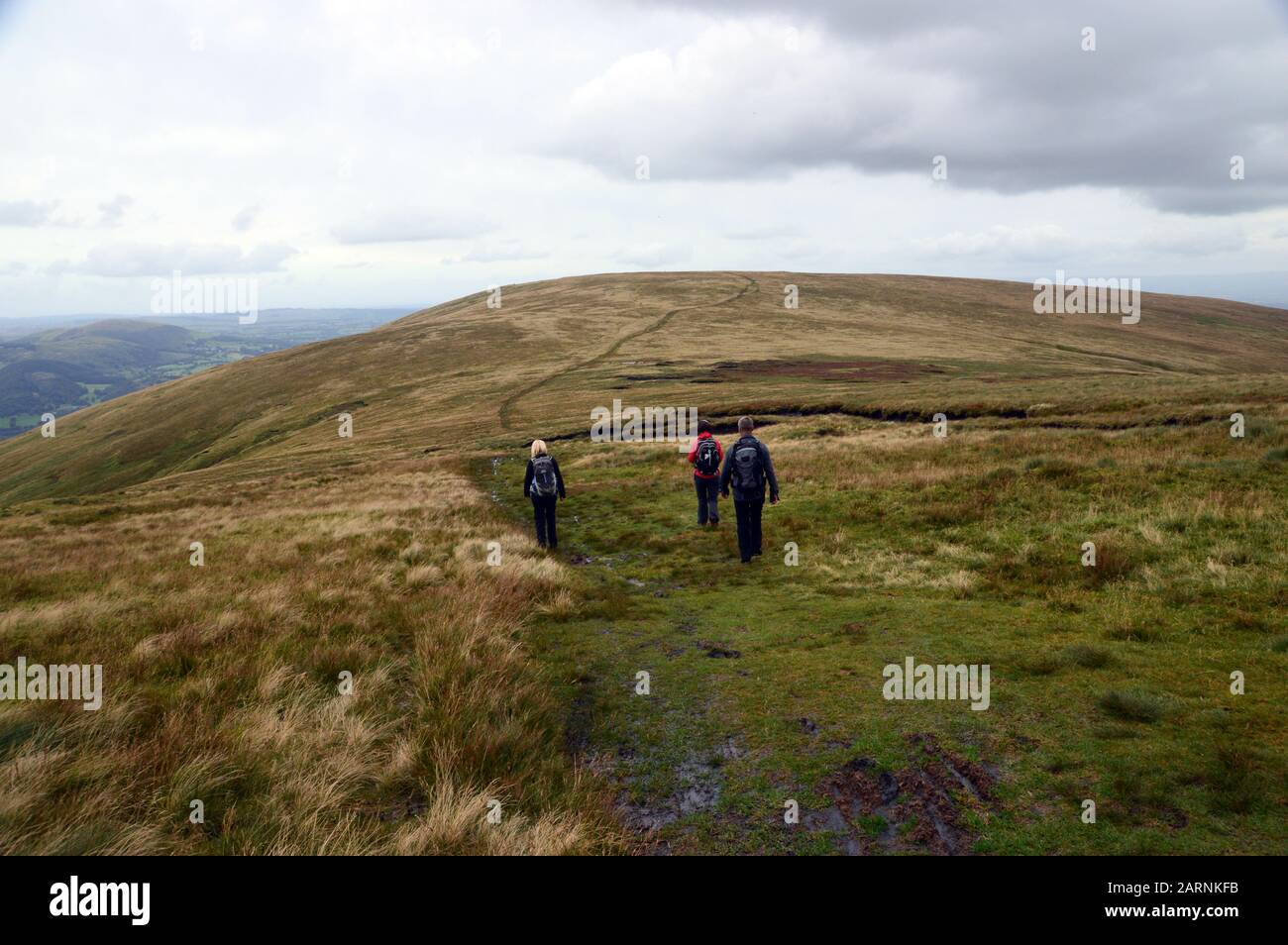 Three People Walking to the Summit of the Wainwright 'Wether Hill' from the Wainwright 'Loadpot Hill' in the Lake District National Park, Cumbria. Stock Photo