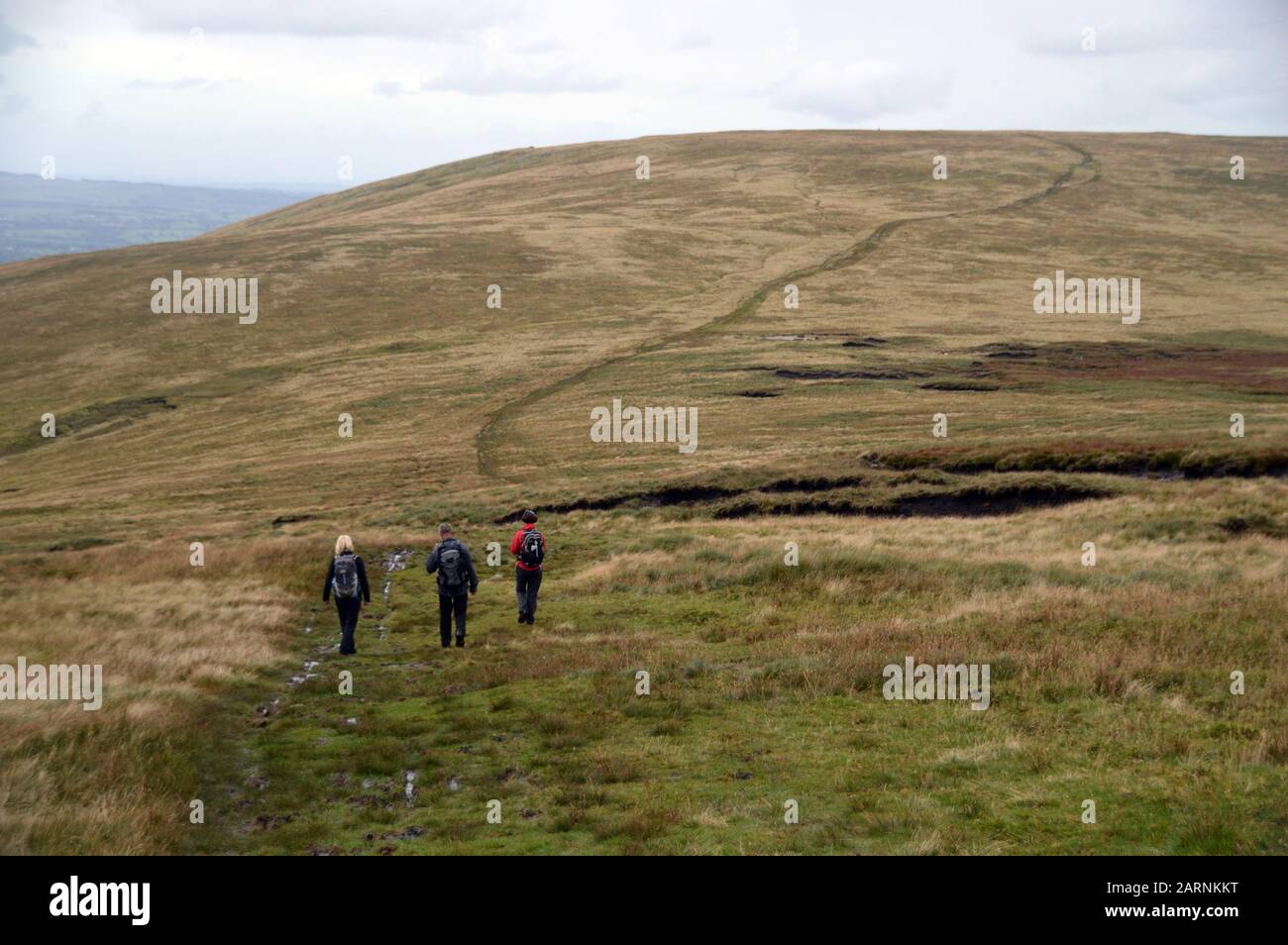 Three People Walking to the Summit of the Wainwright 'Wether Hill' from the Wainwright 'Loadpot Hill' in the Lake District National Park, Cumbria. Stock Photo
