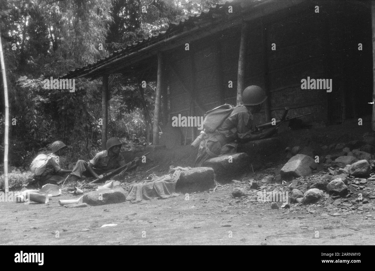 Action of the V-Brigade, Gadja Merah [the Red Elephant] in Bekal and surroundings  [Three KNIL soldiers seem to besiege a house, they are in cover for the porch] Date: 30 March 1949 Location: Bekal, Indonesia, Dutch East Indies Stock Photo