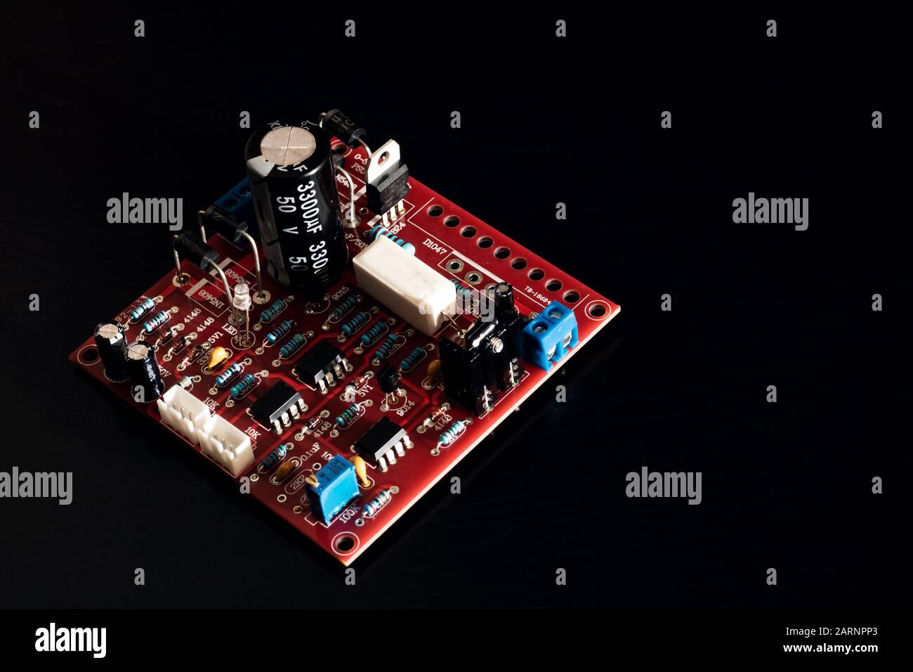 Red PCB with resistors on black background Stock Photo