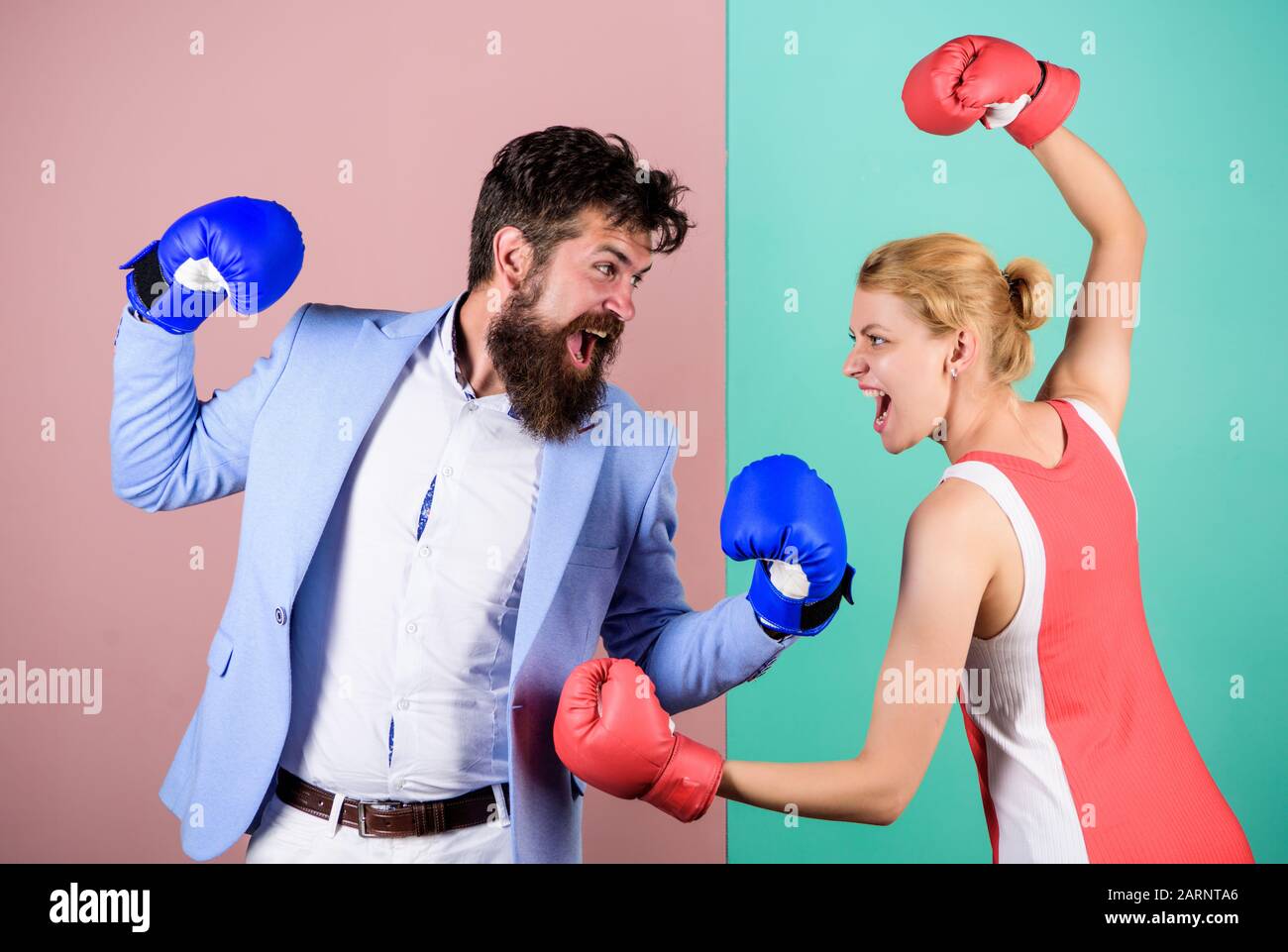 Conflict concept. Family quarrel. Boxers fighting in gloves. Domination concept. Gender battle. Gender equal rights. Gender equality. Man and woman boxing fight. Couple in love competing in boxing. Stock Photo