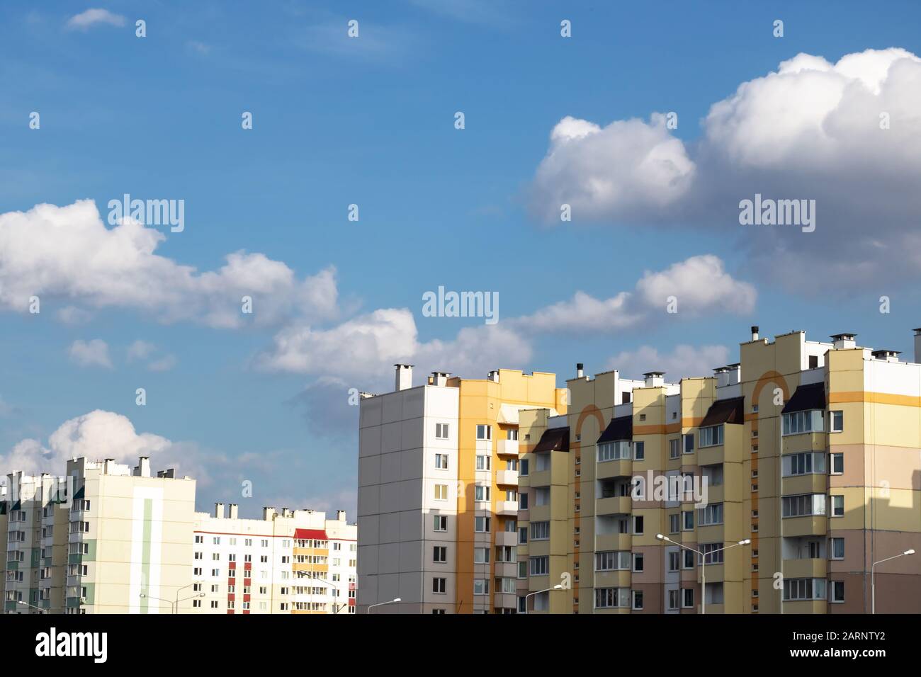 Blue sky and clouds above tall buildings Stock Photo - Alamy