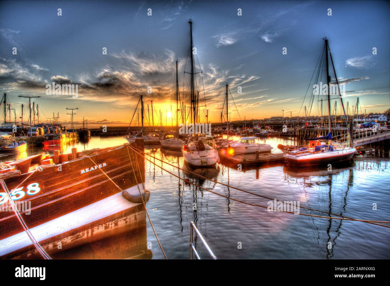 Town of Anstruther, Scotland. Artistic sunset view of leisure and fishing boats berthed at Anstruther Harbour. Stock Photo