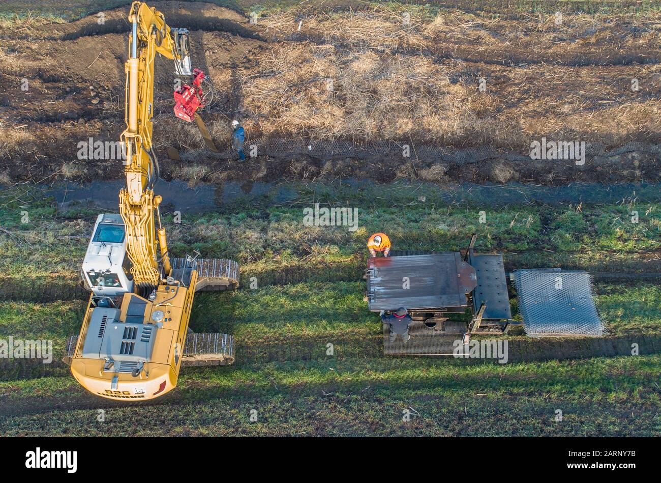 Wriezen, Germany. 27th Jan, 2020. Employees of Ingenieur Wasser und Tiefbau GmbH (IWT) Frankfurt (Oder) are inserting special grids into the soil on one side of a trench (recorded with a drone). The patent of the Frankfurt company slows down the beavers in the Oderbruch. At moats and dikes, vertically buried protective mats prevent nocturnal animals from digging into the ground. Nevertheless, the beaver feels right at home in the cultural landscape. Credit: Patrick Pleul/dpa-Zentralbild/ZB/dpa/Alamy Live News Stock Photo