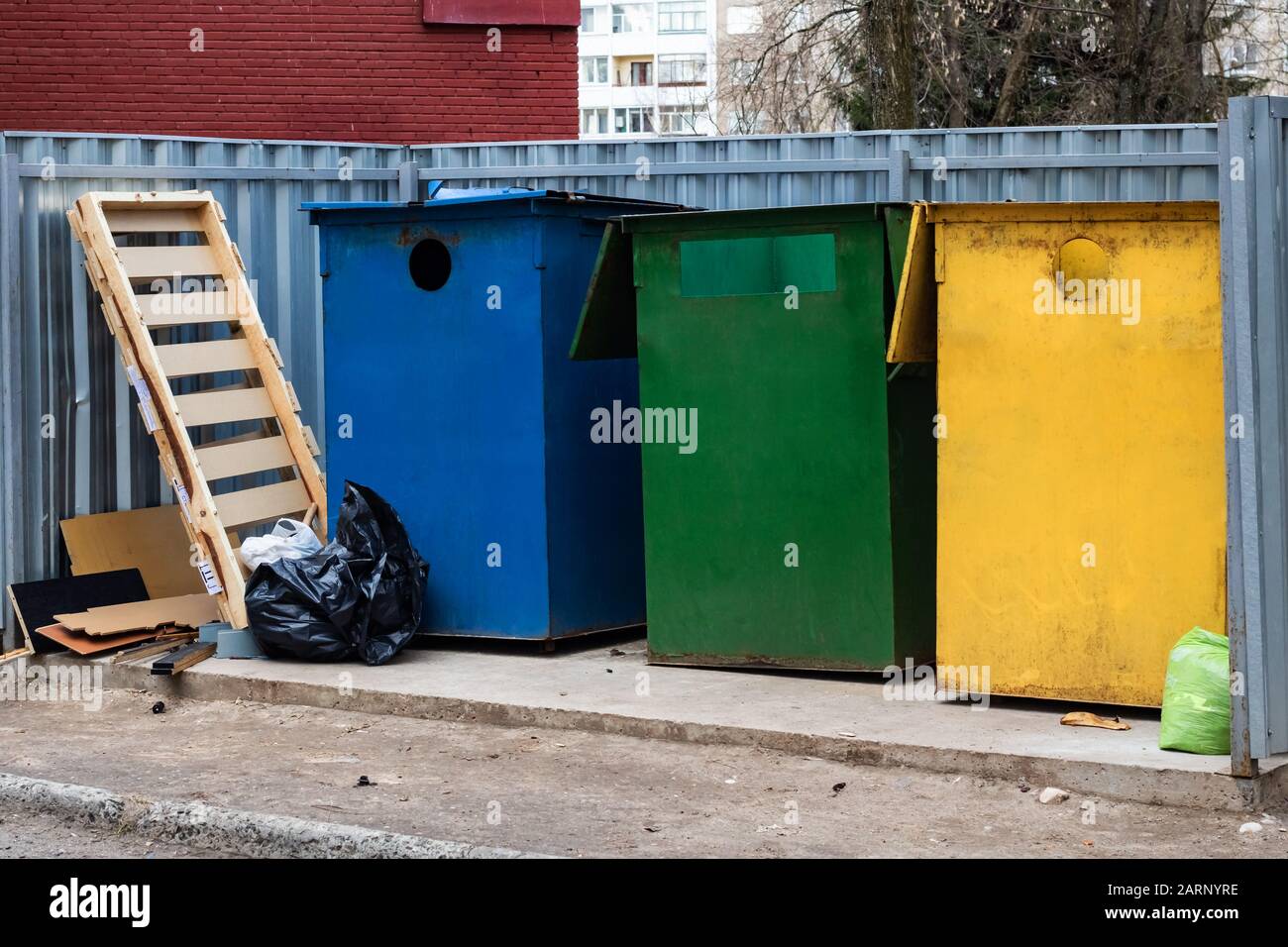 Three large colored trash bins and trash bags Stock Photo Alamy
