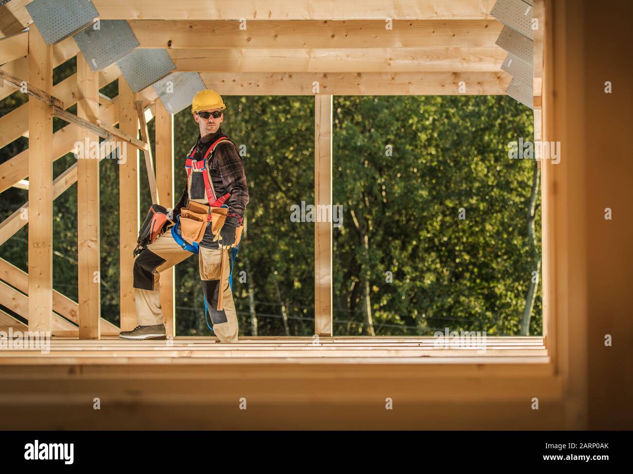 Industrial Theme. Wooden Residential Building Frame Assembly by Professional Contractor Worker. Stock Photo