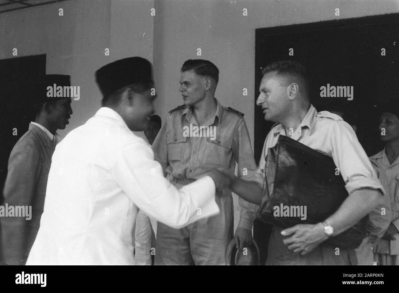 Surroundings Fort de Kock  [Indonesian man with peci shakes the hand of a Dutch man in uniform (administrative officer) with briefcase Date: February 14, 1949 Location: Indonesia, Dutch East Indies, Sumatra Stock Photo