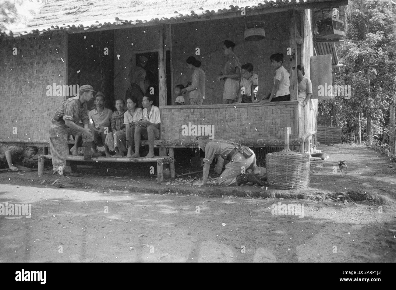 Action Regiment 3 Princess Irene Brigade  Sukb Sector: while the patrol scrupulously searches the houses, the chaplain makes a chat with the population. He is in conversation with a former student of the Bandoengse Technische Hogeschool, who is currently working as tani Date: 29 October 1947 Location: Indonesia, Java, Dutch East Indies Stock Photo