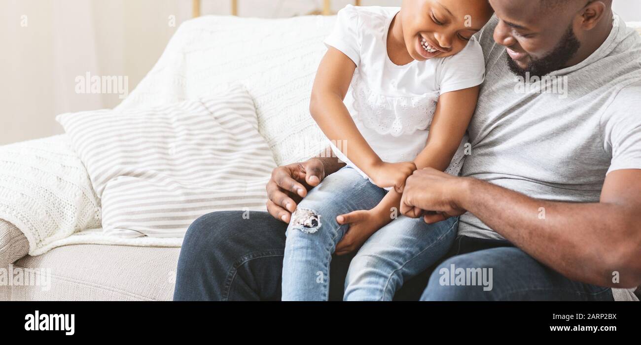 Close up of loving dad tickling his little daughter Stock Photo