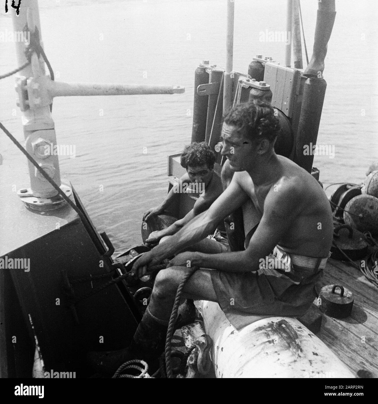 Reportage Hollandia  [Telephony cables laying at sea. Two men on the deck of a ship carrying pulleys] Date: February 1947 Location: Indonesia, Dutch East Indies Stock Photo