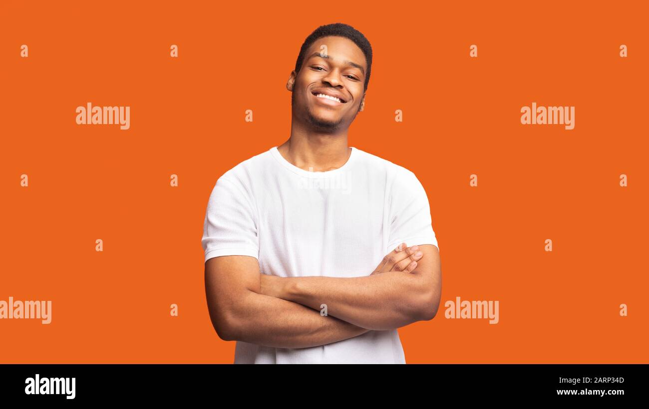 Smiling afro guy portrait on orange background Stock Photo - Alamy