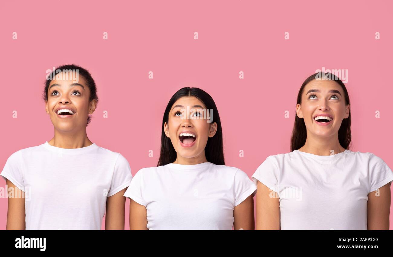Wow. Three Excited Girls Looking Up Standing, Studio Shot Stock Photo