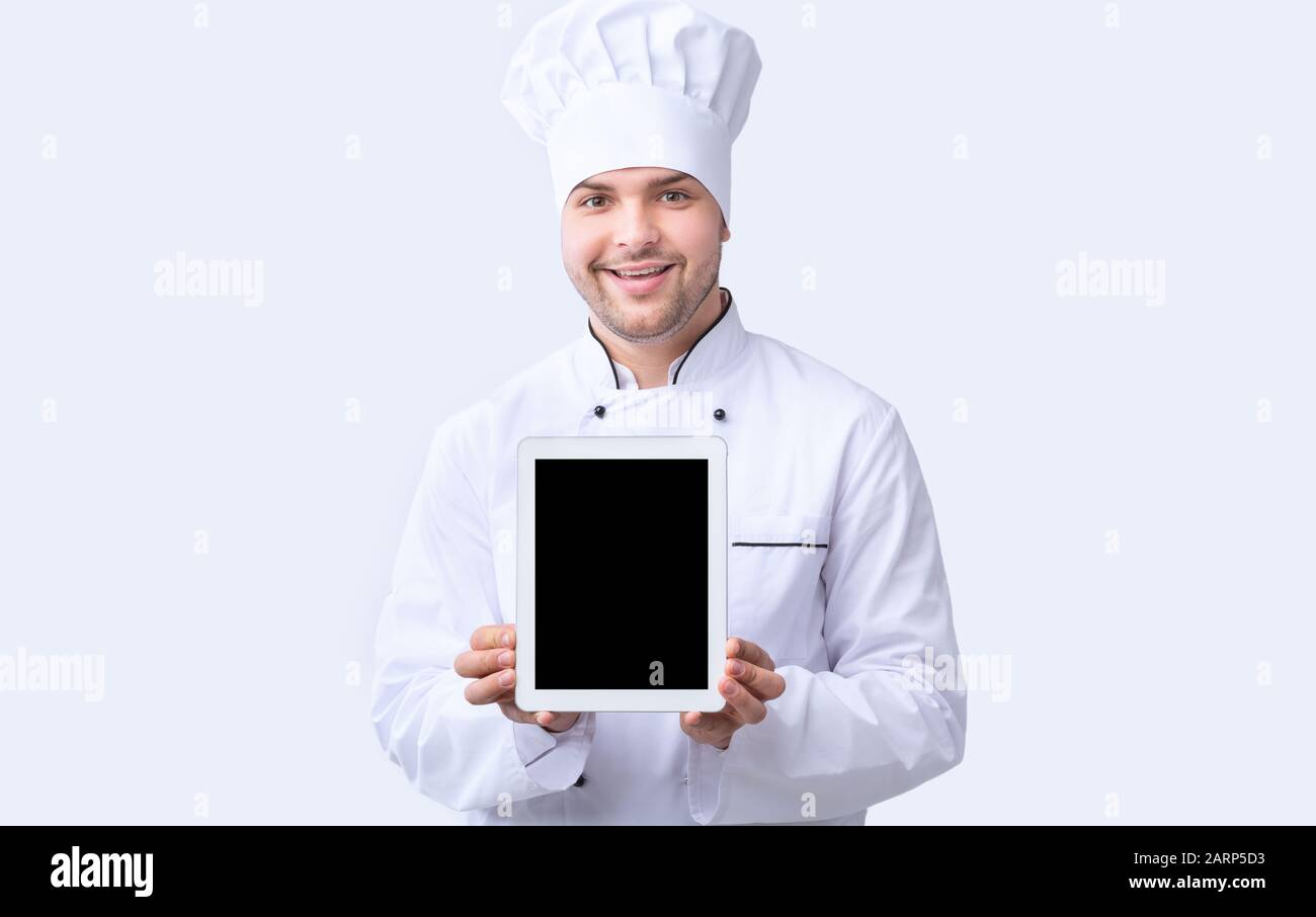Chef Guy Showing Tablet Screen Standing Over White Background, Mockup Stock Photo
