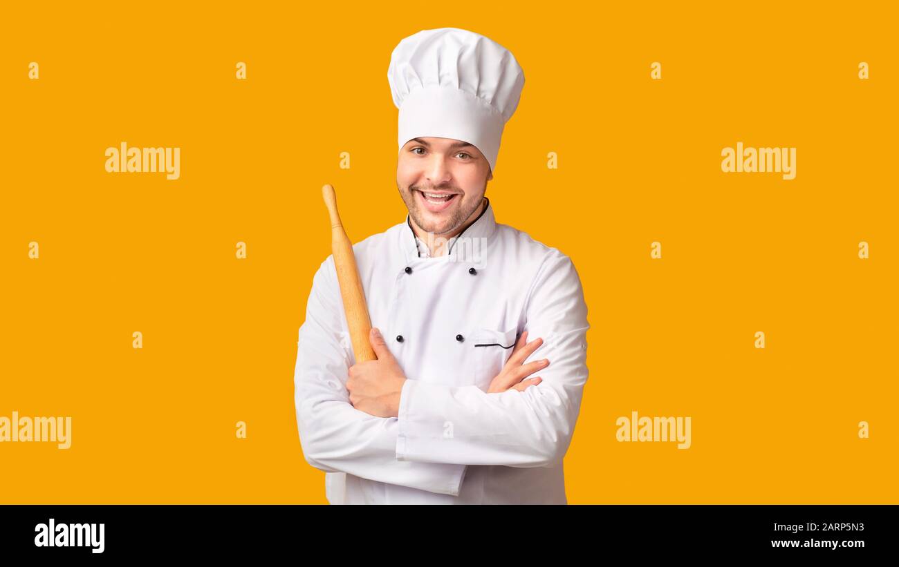 Chef Man Holding Rolling Pin Standing On Yellow Background, Panorama Stock Photo