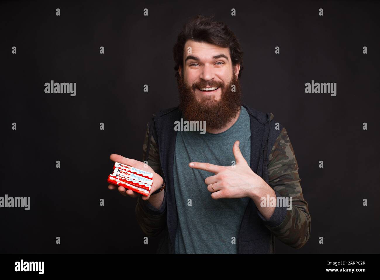 https://c8.alamy.com/comp/2ARPC2R/moldova-chisinau-3-january-2020-amazed-young-bearded-man-showing-tasty-kinder-chocolate-2ARPC2R.jpg