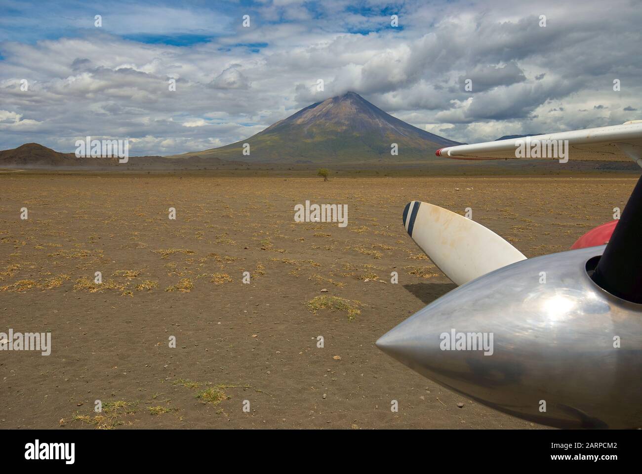 A Cessna 206 on the ground at Engaresero airstrip, next to the volcano Oldoinyo Lengai (Tanzania) Stock Photo