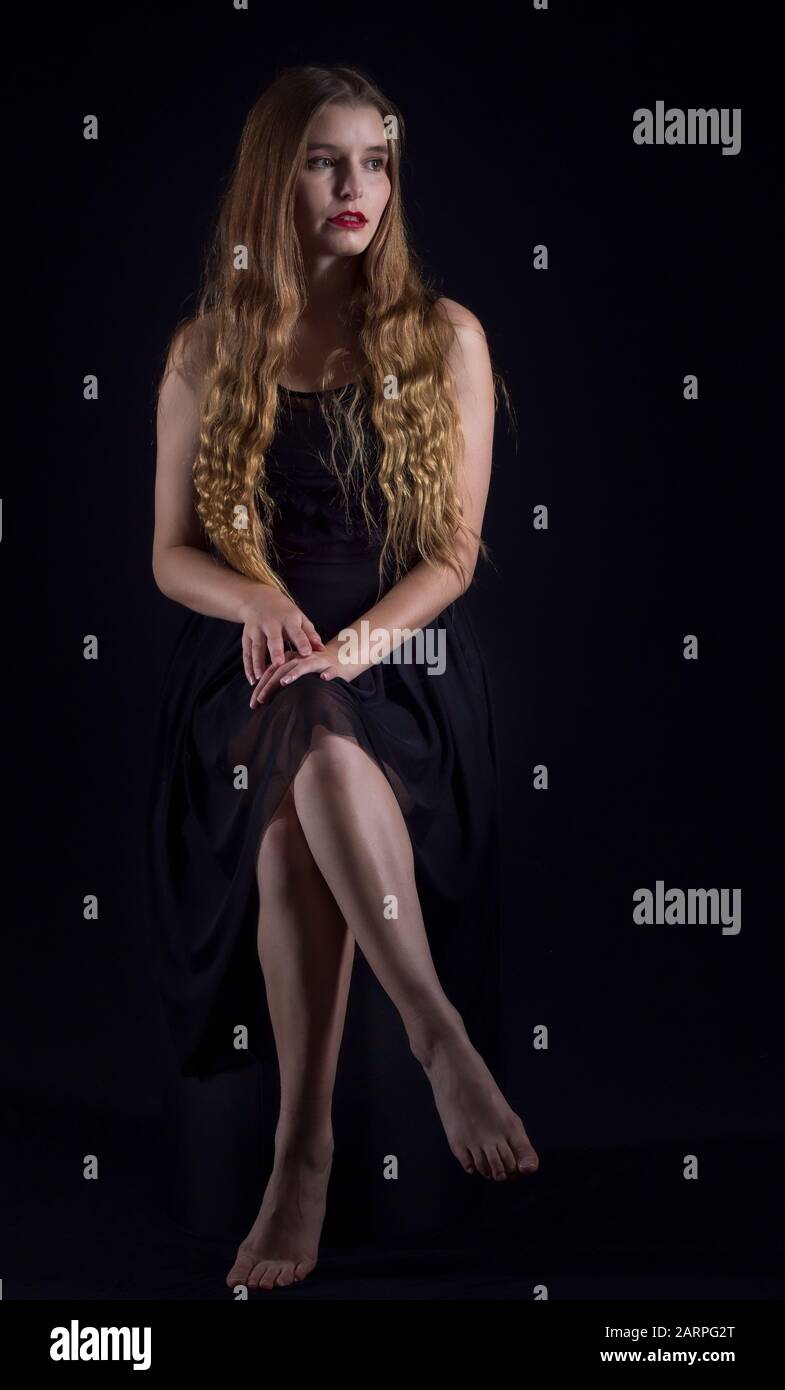 Young woman posing in stylish outfit in a studio setting Stock Photo