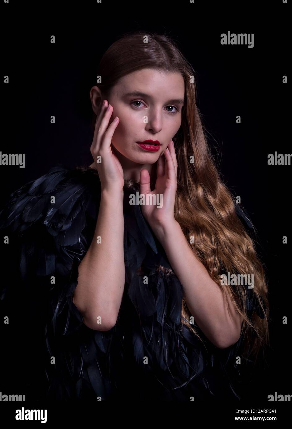 Attractive woman posing in a black dress in a studio setting Stock Photo