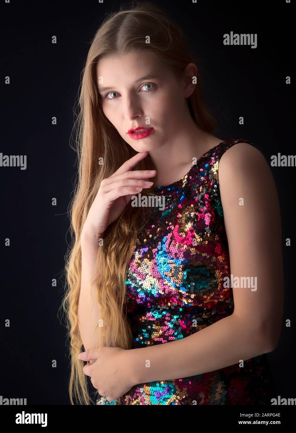 Young woman posing in stylish outfit in a studio setting Stock Photo