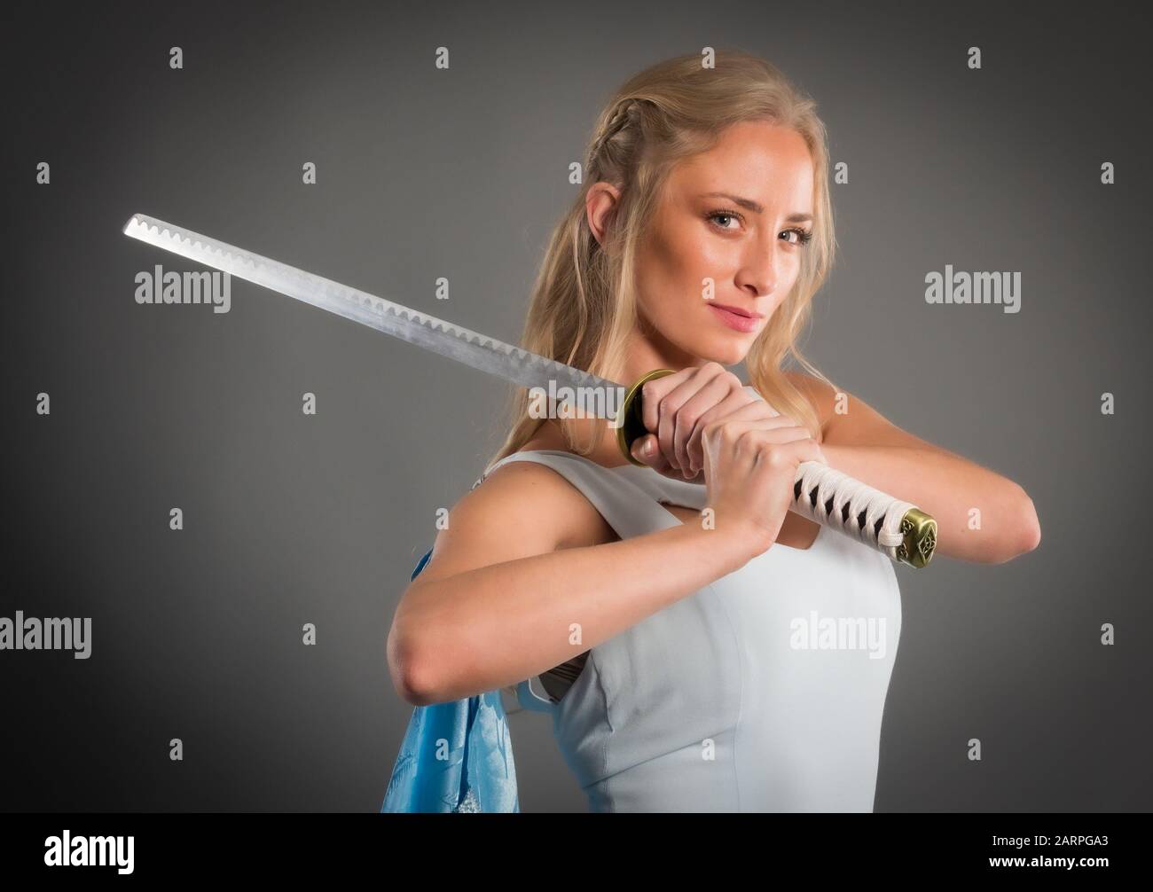 Cosplay style model in studio setting holding a sword Stock Photo