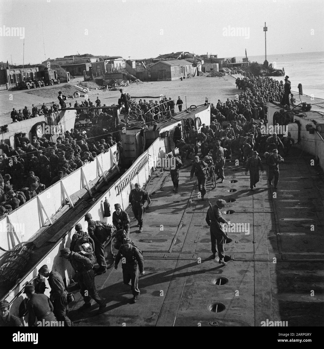 Capitulation: Den Helder  In Den Helder, the disarmed German soldiers are embarked in LCT boats for Harlingen, from where the long journey to the Heimat is made on foot. Date: 1945 Location: Den Helder Keywords: prisoners of war, ships, World War II Stock Photo