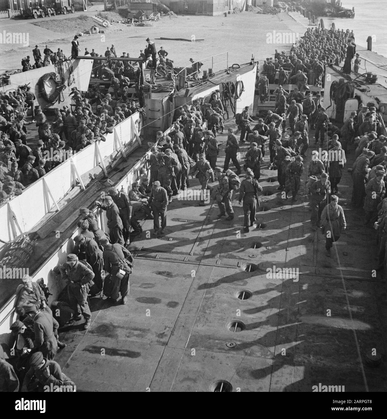 Capitulation: Den Helder  In Den Helder, the disarmed German soldiers are embarked in LCT boats for Harlingen, from where the long journey to the Heimat is made on foot. Date: June 1945 Location: Den Helder Keywords: prisoners of war, ships, World War II Stock Photo