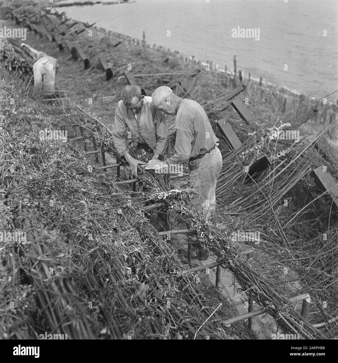 Devastations: Flushing Two workers engaged in raising work Date: 1945 ...