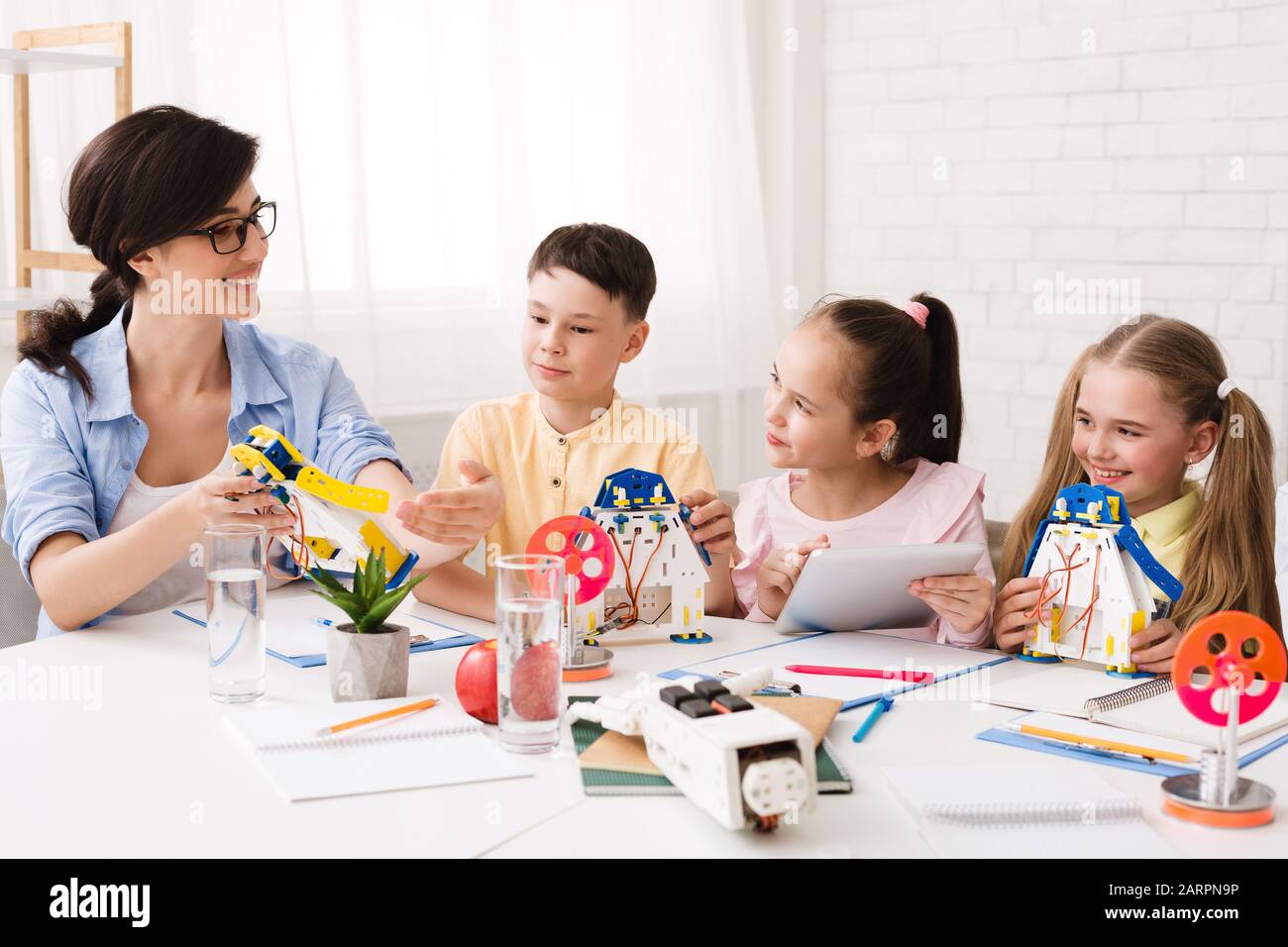 Teacher explaining children how to make modern robot Stock Photo
