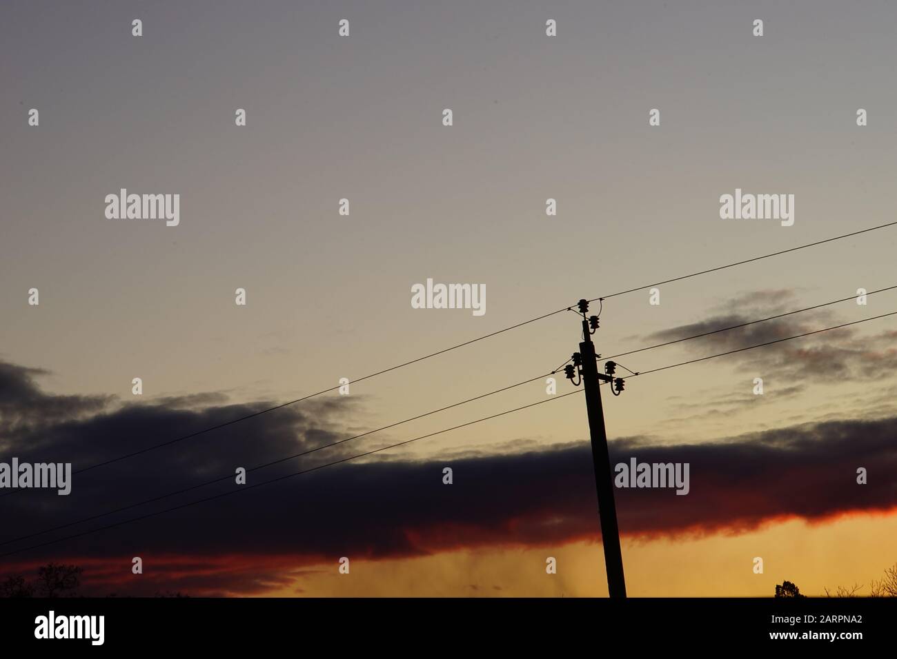 Silhouette high voltage electric tower in dark sunset sky Stock Photo ...