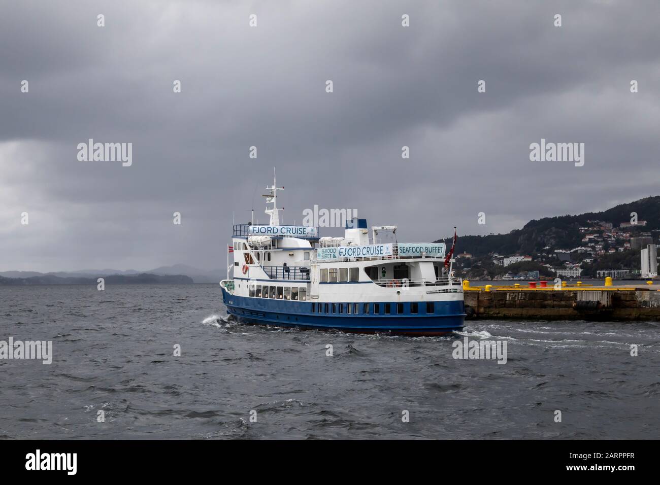 Passenger ship Lykkeper departing from the port of Bergen, Norway. Passing Skolten quay. Stock Photo