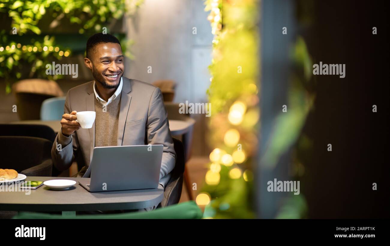 Afro manager drinking tea and using personal computer Stock Photo