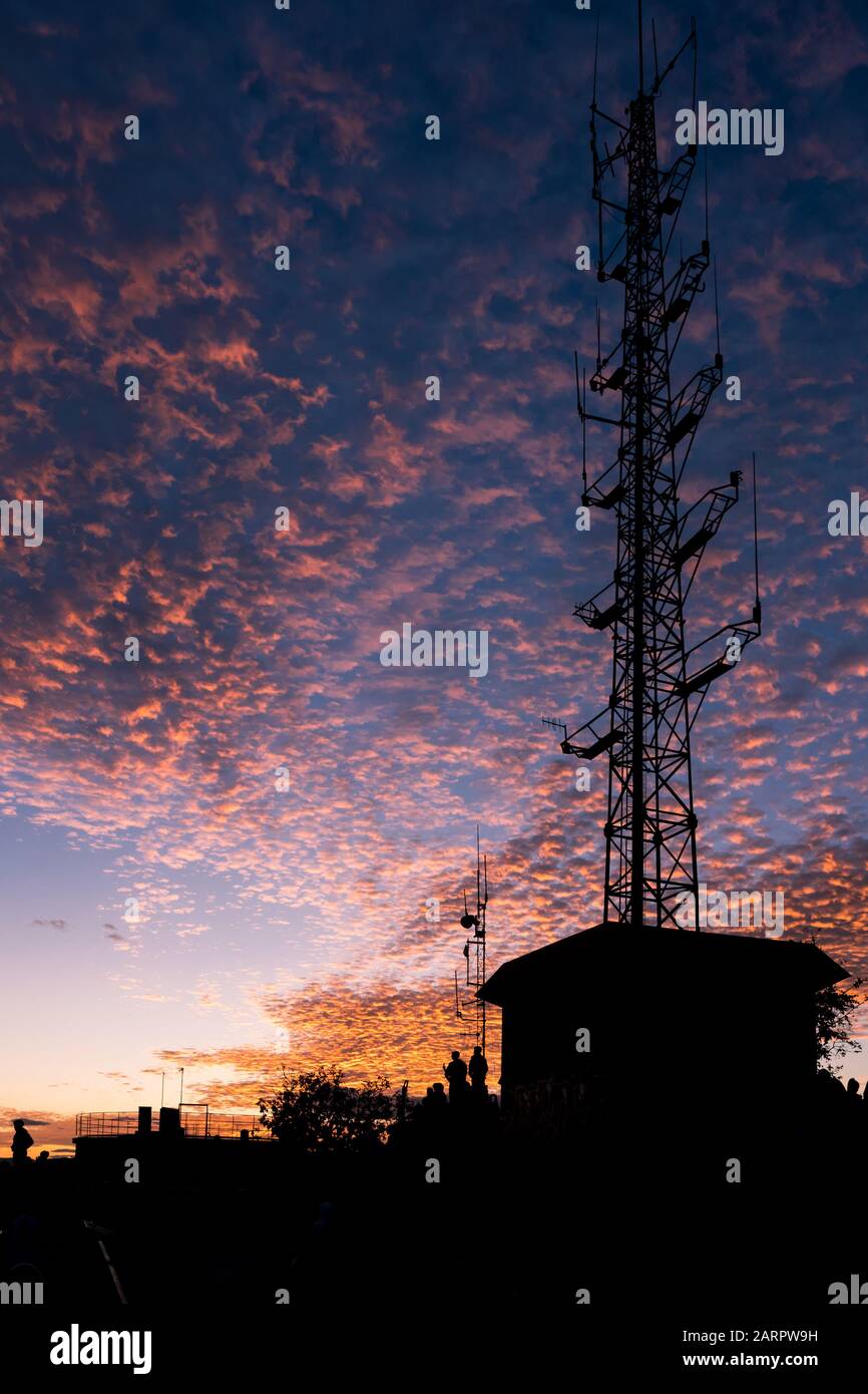 Burning Clouds During Sunset With Radio Antenna Mast Stock Photo