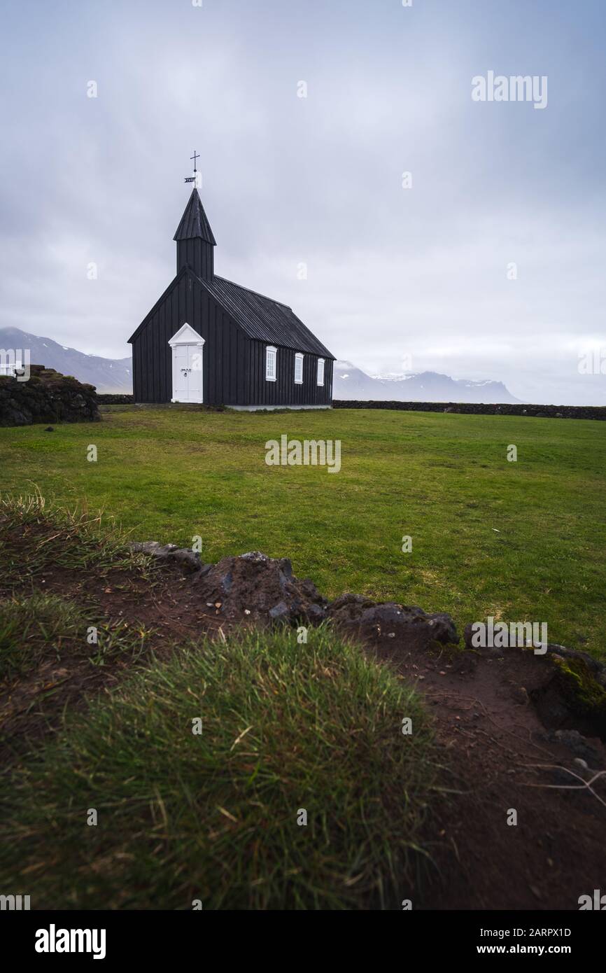 Búðakirkja, the coastal black church of Iceland, located on the south coast of Iceland's Snæfellsnes peninsula. Stunning white door and epic overcast Stock Photo