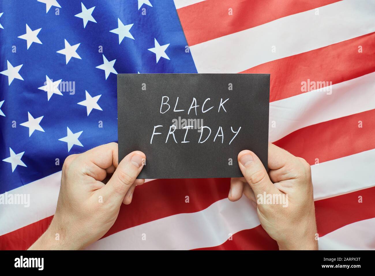 Black friday in USA concept. Notification in hands of Black Friday sales  start on United States of America flag background Stock Photo - Alamy