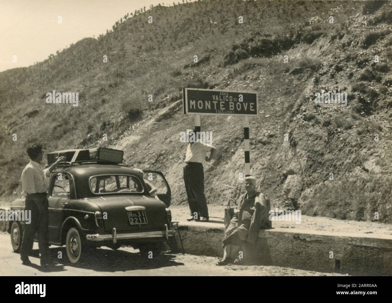 Small family group with car during a pitstop at Monte Bove pass, Italy 1950s Stock Photo
