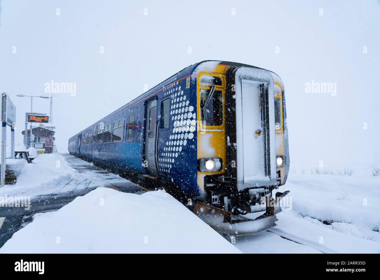 Scotrail train at Corrour Station in snow  on way to Mallaig on the West Highland Line. Corrour Station is the highest in the UK. Stock Photo