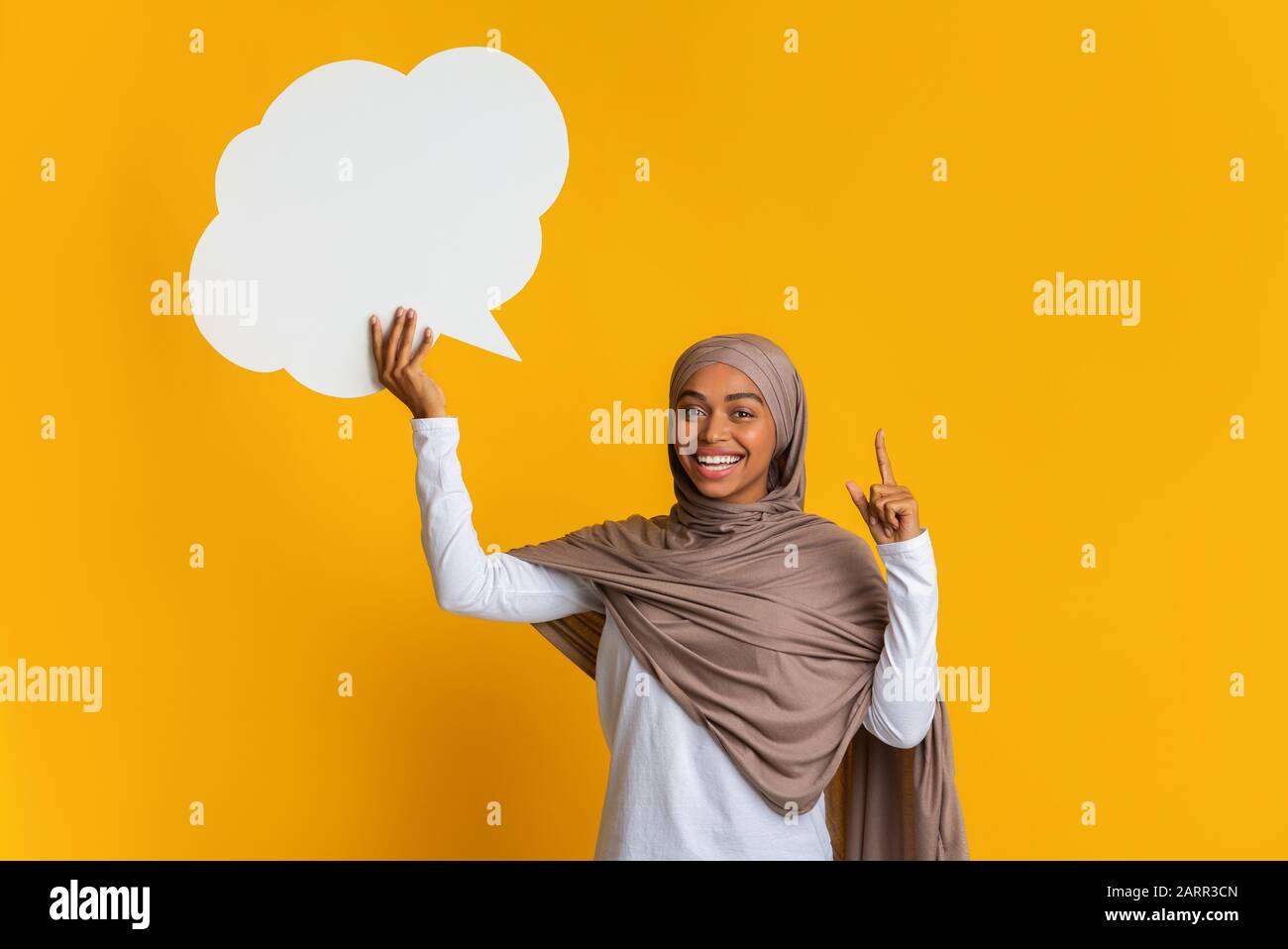 Inspired black woman in hijab holding empty speech bubble, having idea ...