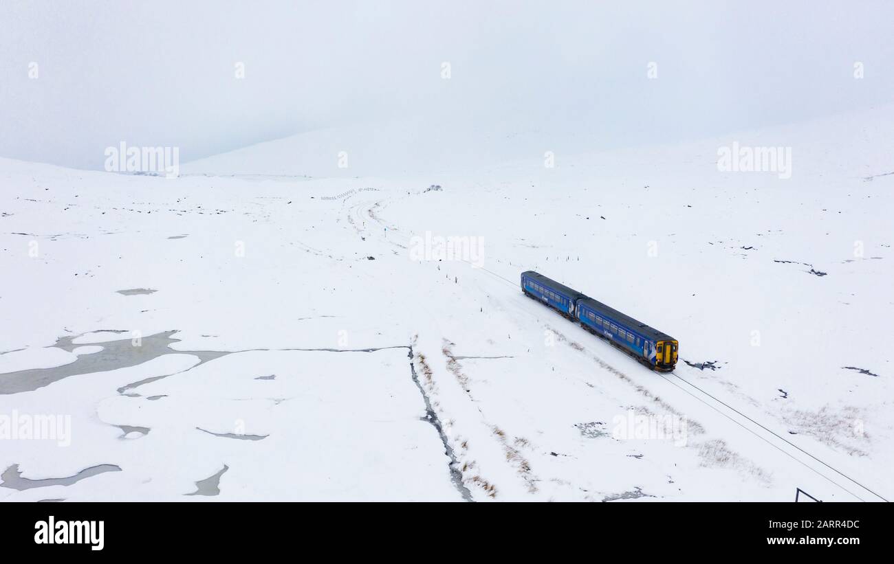 A Scotrail train travels through heavy snow at Corrour on route from Mallaig to Glasgow on the West Highland Line. Corrour is highest station in UK. Stock Photo