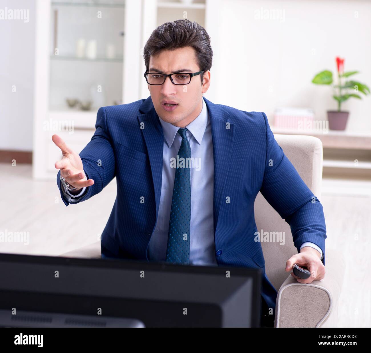 The businessman watching tv in the office Stock Photo Alamy