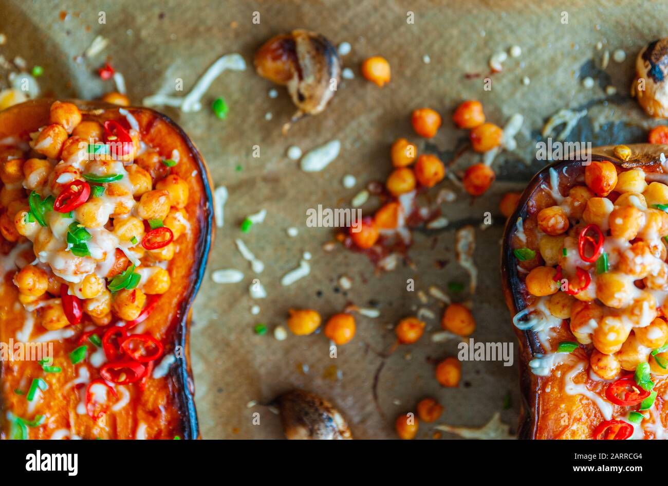Above shot of a roasted butternut squash topped with chickpea, pepper and cheese Stock Photo