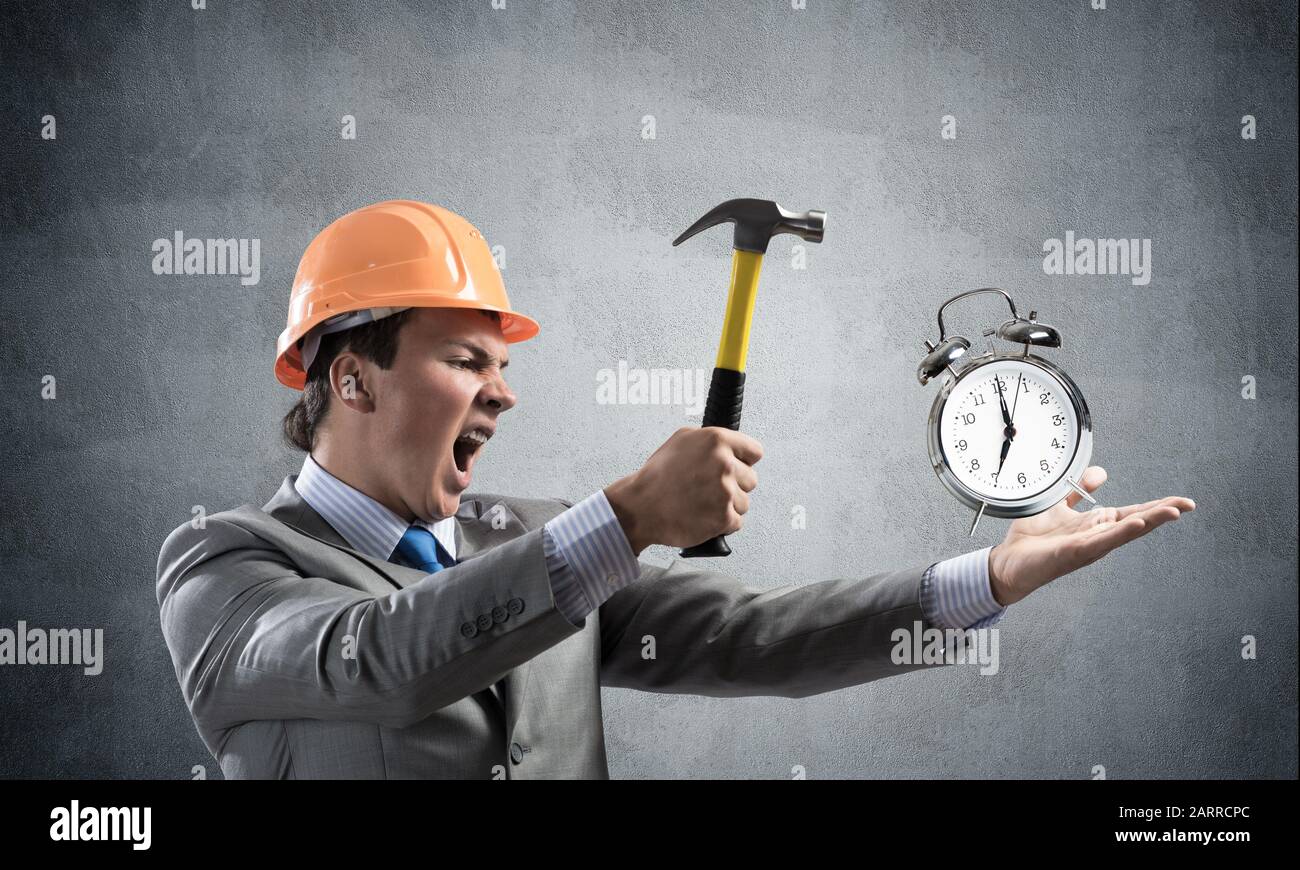 Businessman going to crash with hammer alarm clock Stock Photo Alamy