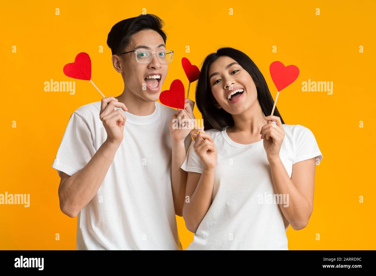 Happy asian couple holding red heart shaped cards Stock Photo - Alamy