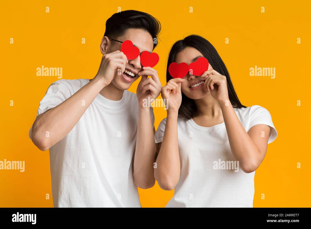 Asian couple in love covering eyes with valentine cards Stock Photo