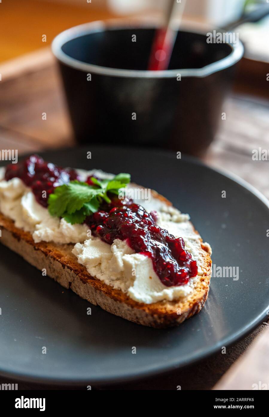 Close up shot of a slice of a bread topped with ricotta cheese and jar Stock Photo