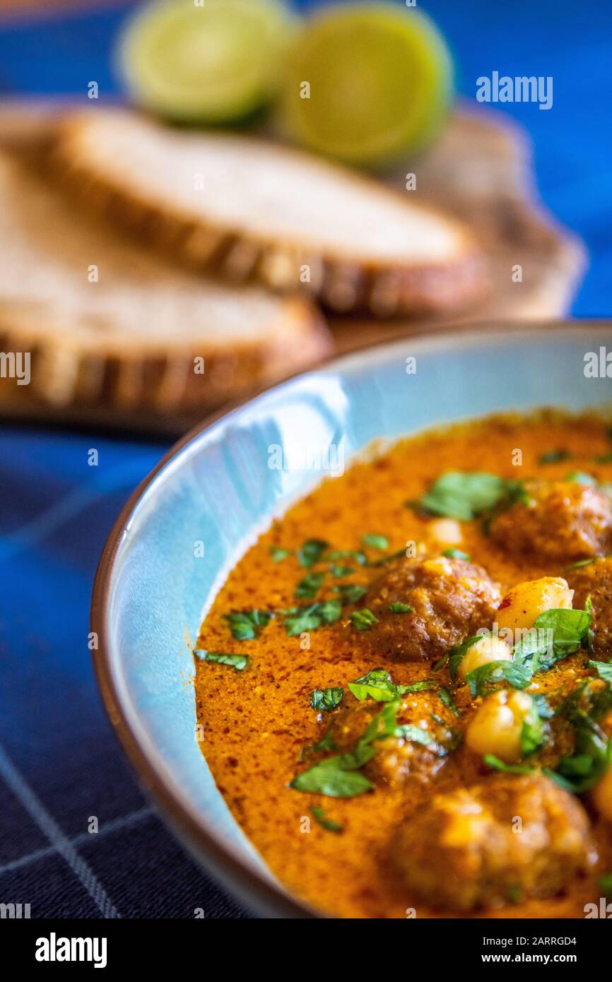 Close up shot of a bowl of meatball soup with herbs Stock Photo
