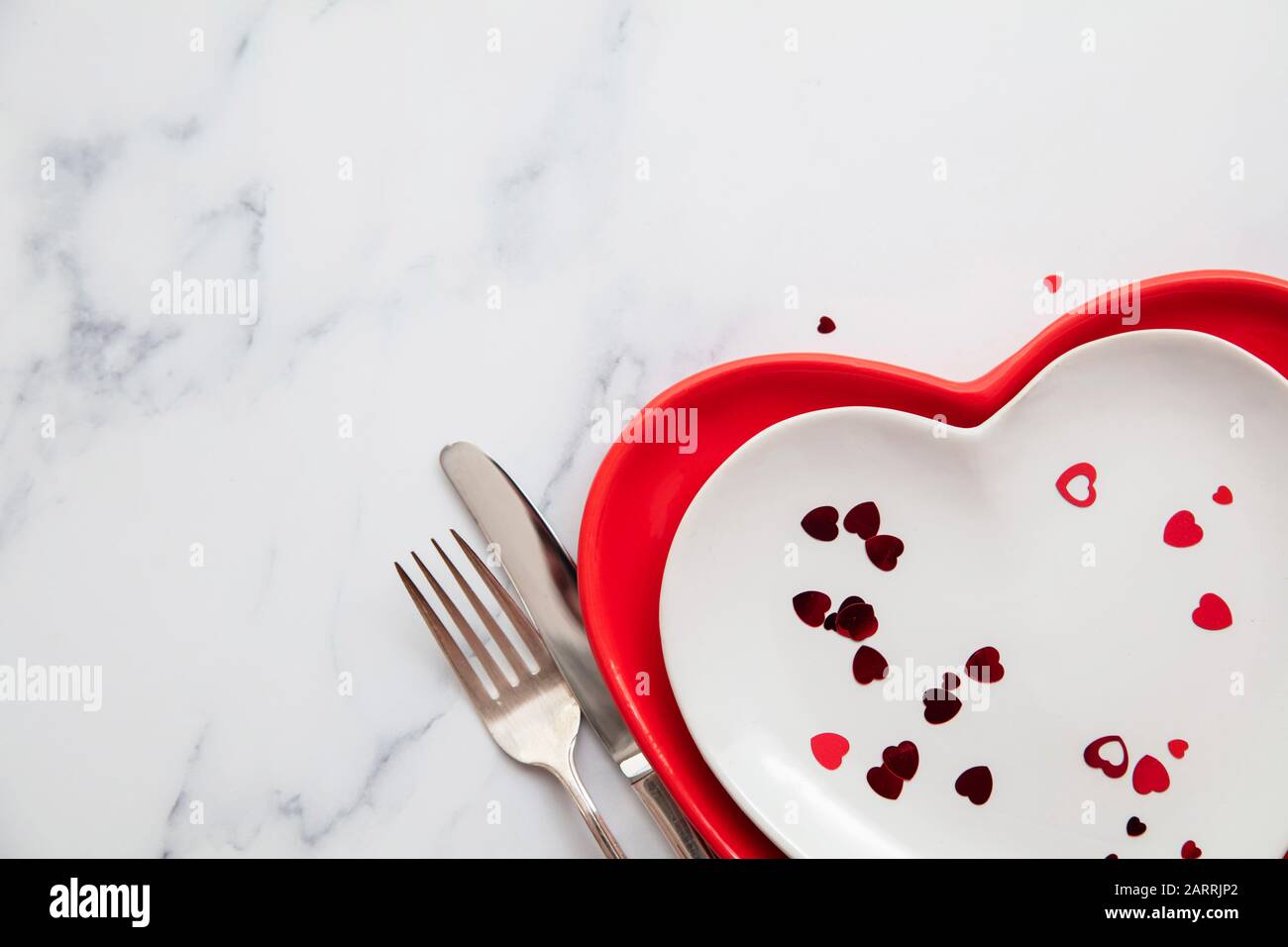 Valentine's day red and white dinner plates with heart shaped confetti  Stock Photo - Alamy