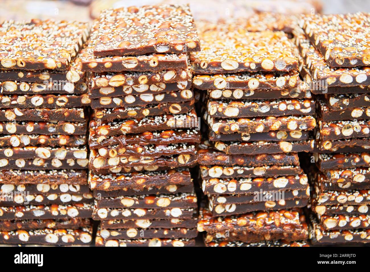 A pile of peanut brittle bars covered with sesame seeds for sale at a market in the Visayas, Philippines Stock Photo