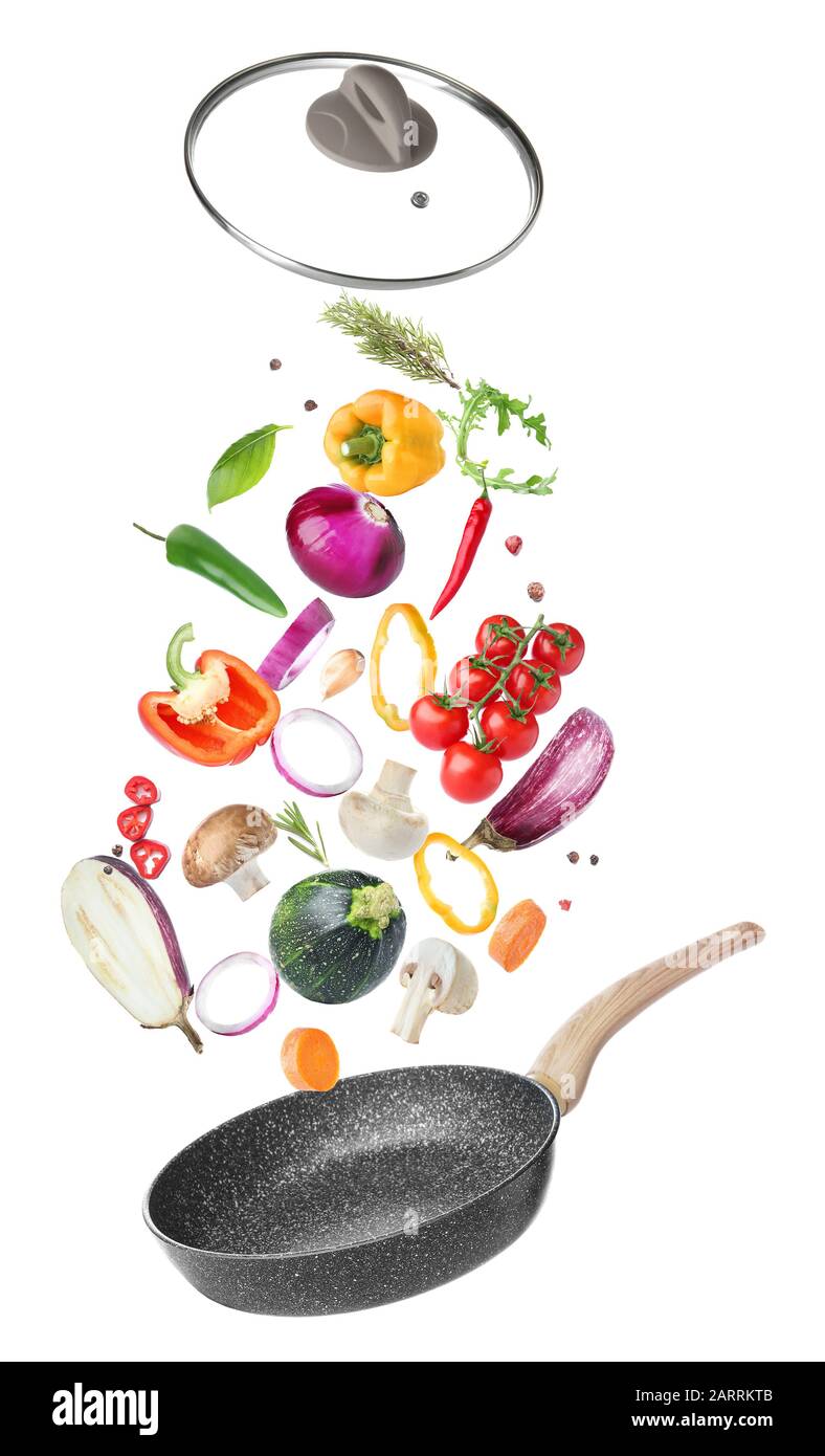Frying pan and flying vegetables on white background Stock Photo